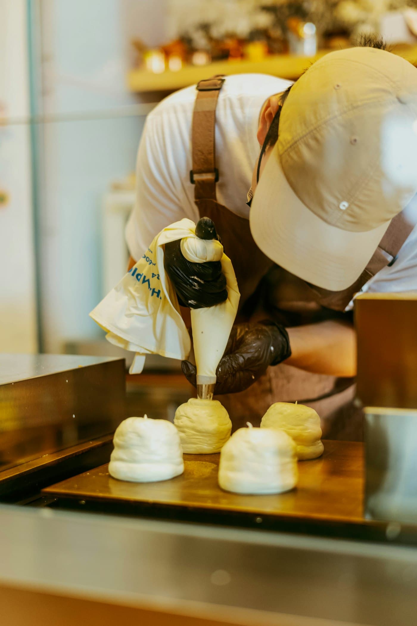 Repostero formando merengue con una manga pastelera